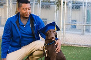 Trainer hugging successful dog